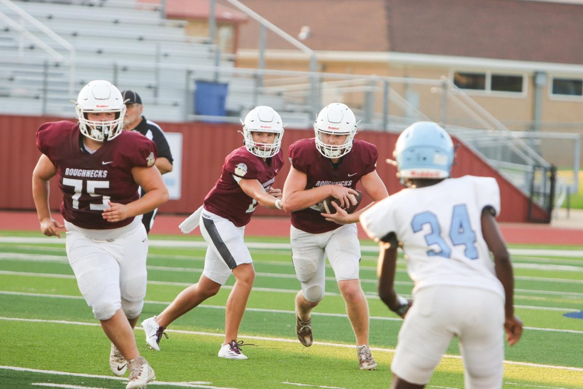 Sophomore Tucker Ludlow hands the ball off to senior Levi Sipes in the scrimmage against the West Rusk Raiders Thursday night. 